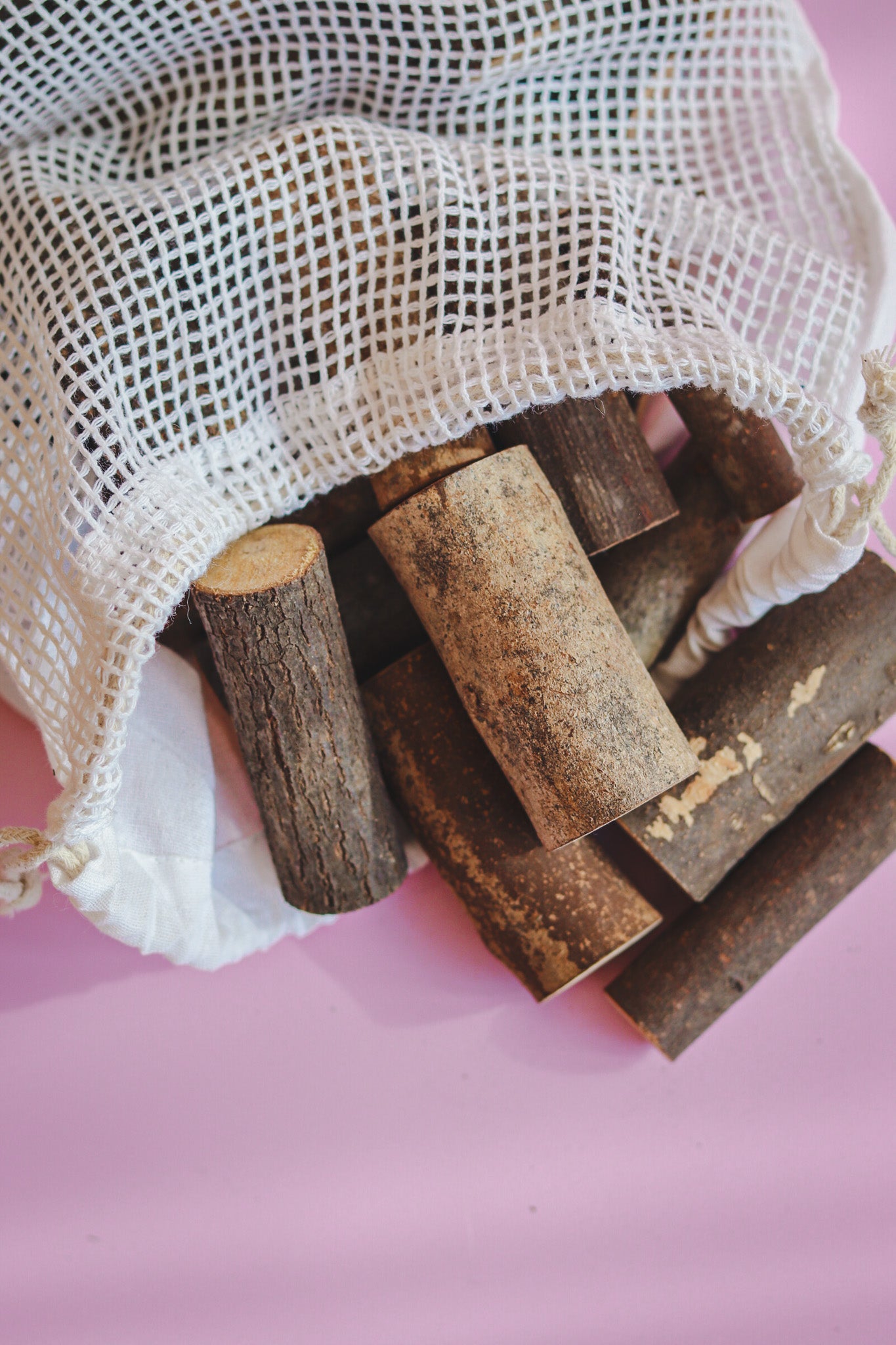 Houten boomstammetjes in katoenen zakje